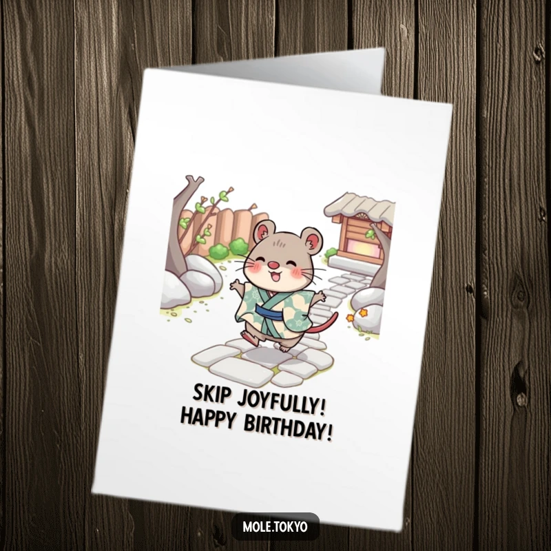 Funny Free Printable Birthday Card showing a cheerful mole character in a patterned kimono skipping playfully across a rustic stone path.